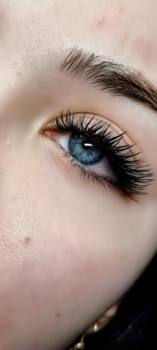 Close-up of a client with dramatic eyelash extensions showing length and volume